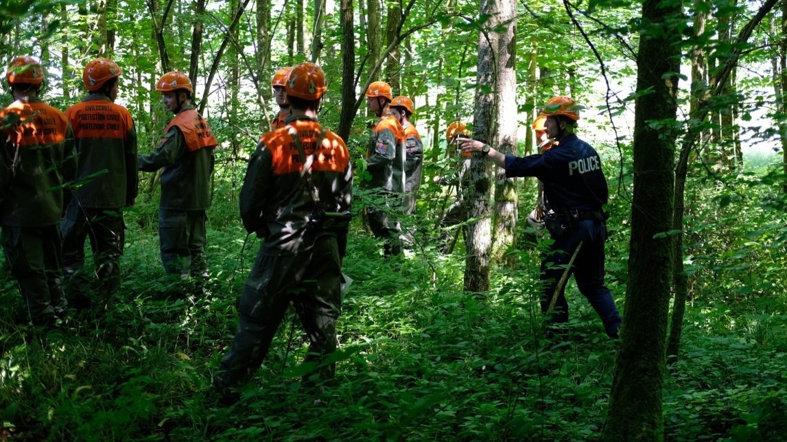 Übungsteilnehmer suchen im Wald nach vermissten Pfadfinder