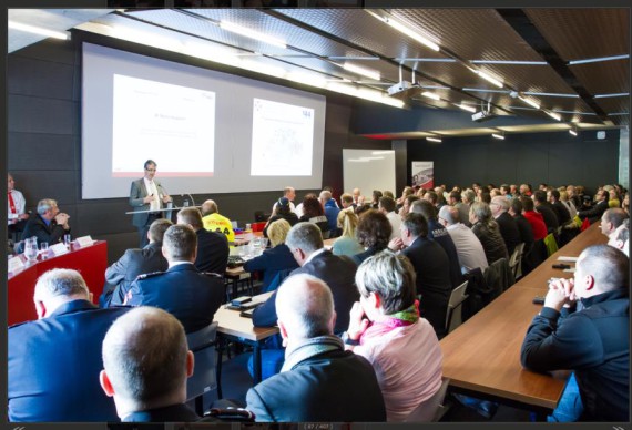 La photo donne un aperçu d'un auditoire où sont réunies des personnes assistant à la présentation du nouveau logiciel.